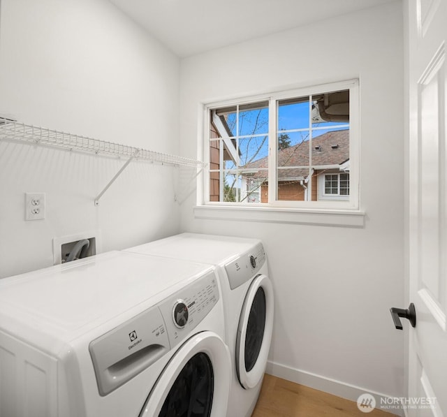 laundry room with laundry area, light wood-style flooring, baseboards, and washer and clothes dryer