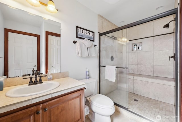 bathroom with vanity, toilet, and a shower stall