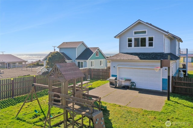 rear view of house featuring a playground, roof with shingles, a yard, a garage, and driveway