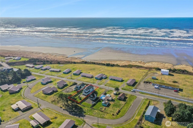 drone / aerial view with a beach view and a water view