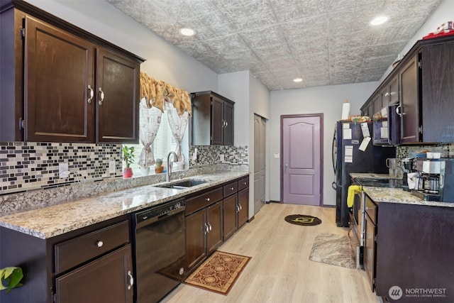 kitchen featuring a sink, dark brown cabinets, black appliances, and light wood finished floors