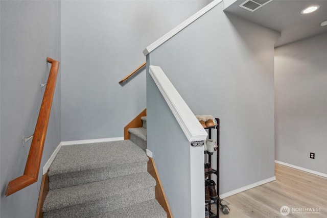 stairway featuring recessed lighting, wood finished floors, and baseboards