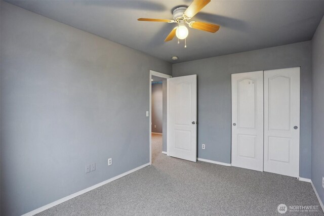 unfurnished bedroom with a closet, a ceiling fan, baseboards, and carpet floors