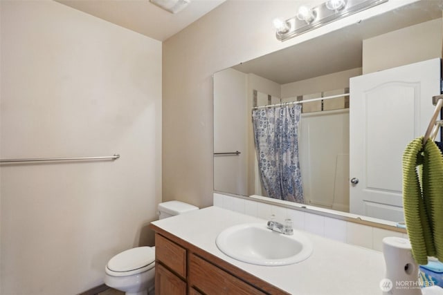 full bathroom featuring vanity, a shower with shower curtain, and toilet