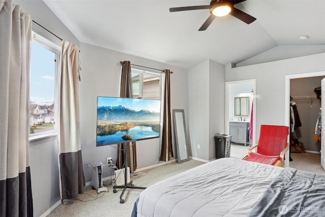 bedroom featuring baseboards, carpet floors, vaulted ceiling, a spacious closet, and connected bathroom