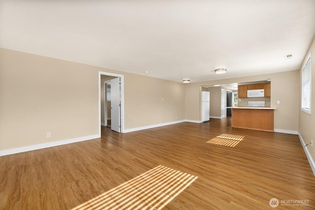 unfurnished living room with visible vents, baseboards, and wood finished floors