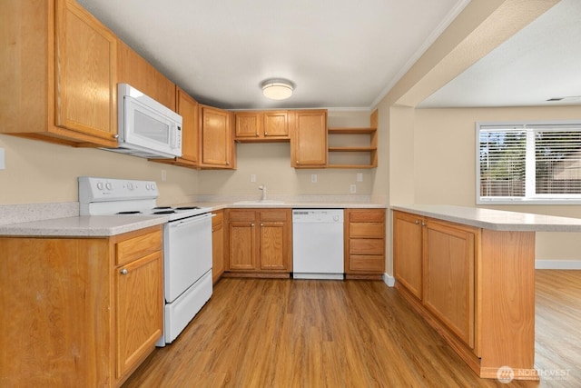 kitchen with light wood finished floors, white appliances, a peninsula, and light countertops