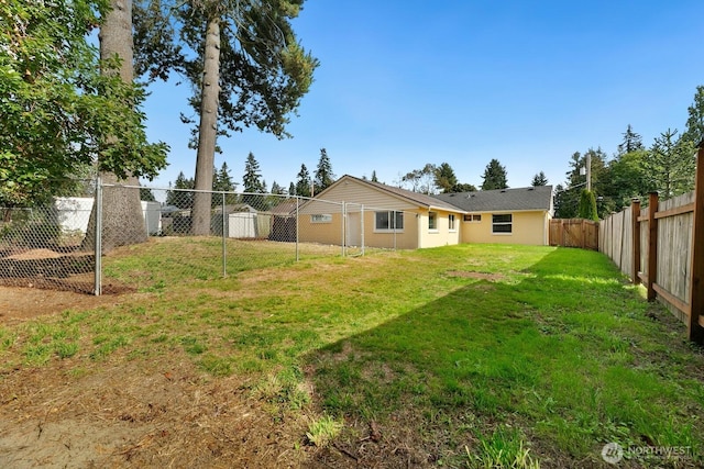 back of house with a lawn and a fenced backyard