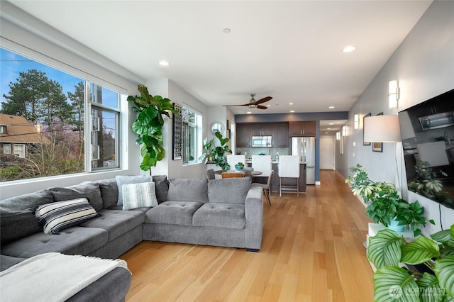 living area with recessed lighting, light wood-style floors, and ceiling fan