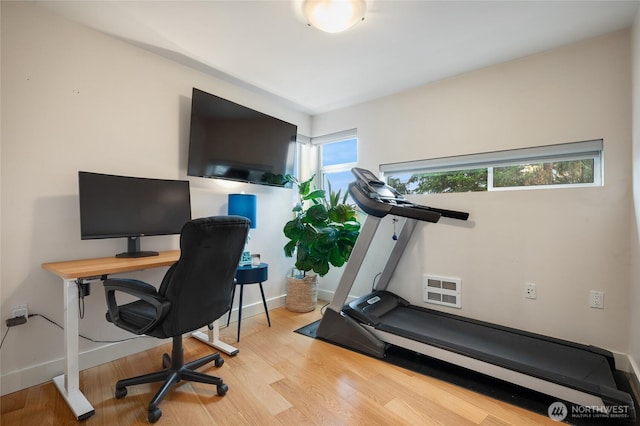 office area with visible vents, baseboards, and wood finished floors