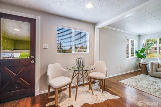 sitting room featuring crown molding, wood finished floors, baseboards, and a textured ceiling