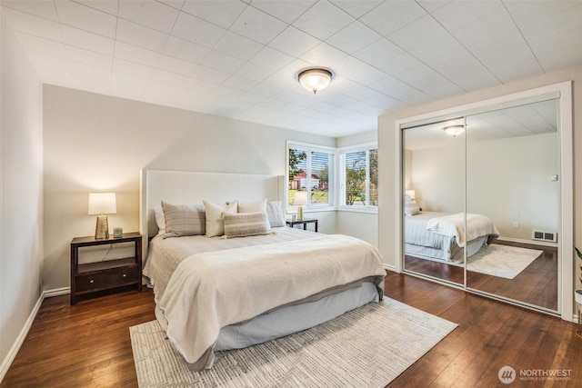 bedroom featuring visible vents, baseboards, a closet, and wood-type flooring