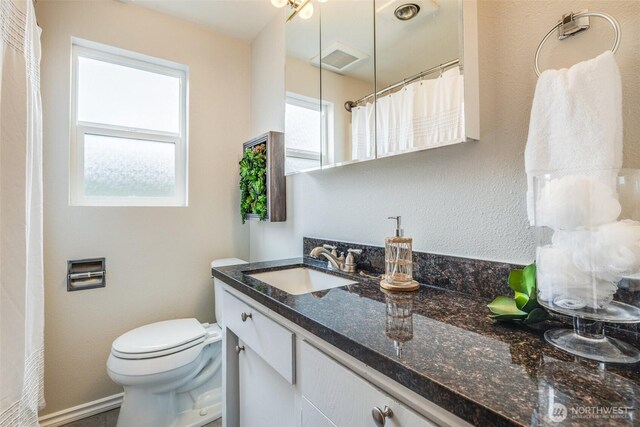 bathroom with vanity, toilet, a shower with curtain, and visible vents