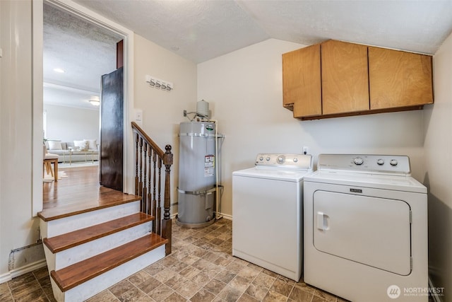 laundry area featuring cabinet space, secured water heater, baseboards, and washing machine and clothes dryer