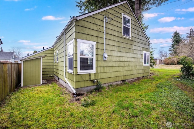 view of side of property featuring a yard and fence