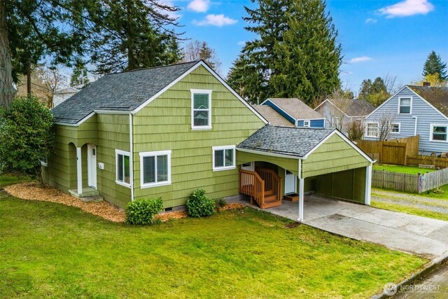 rear view of house featuring crawl space, a lawn, driveway, and fence