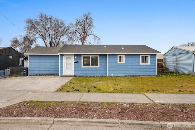 single story home with driveway, a shingled roof, a front lawn, and fence