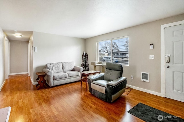 living area with baseboards and light wood-style flooring