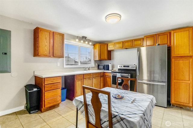 kitchen featuring electric panel, a sink, appliances with stainless steel finishes, light tile patterned flooring, and light countertops