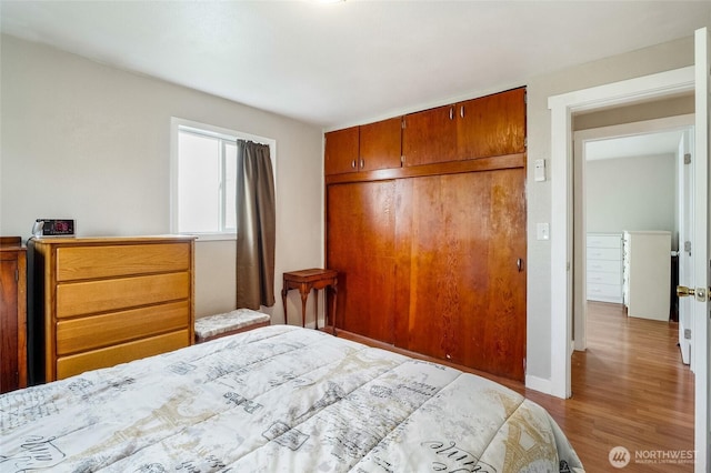 bedroom with a closet, baseboards, and wood finished floors