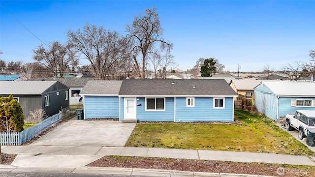 view of front of property featuring concrete driveway, fence, a front lawn, and a shingled roof