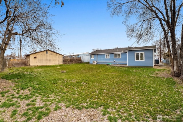 back of house with a yard, an outdoor structure, and a fenced backyard