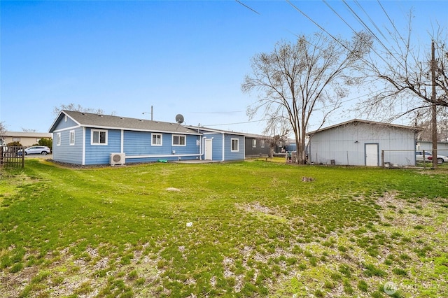 rear view of house featuring a lawn and fence