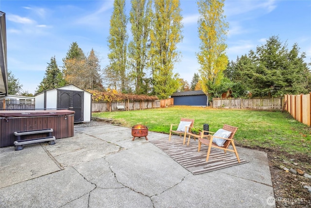 view of patio featuring an outdoor structure, a fenced backyard, a shed, and an outdoor fire pit