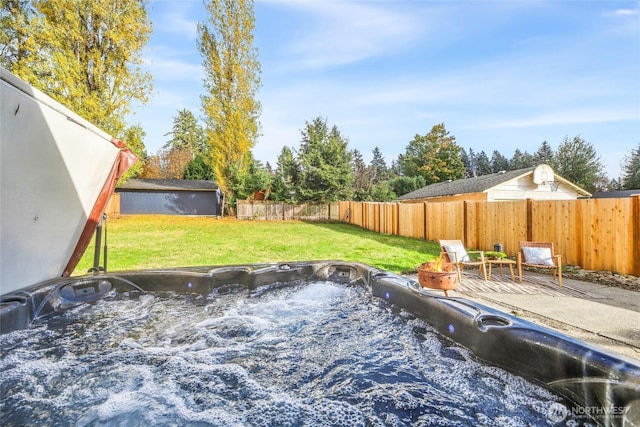 view of yard with a patio area, an outdoor structure, a fenced backyard, and a hot tub