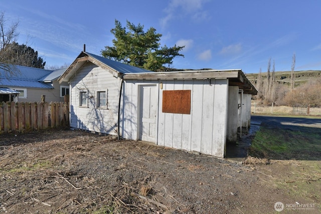 view of outbuilding featuring fence