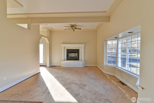 unfurnished living room featuring visible vents, a fireplace with raised hearth, baseboards, and ceiling fan