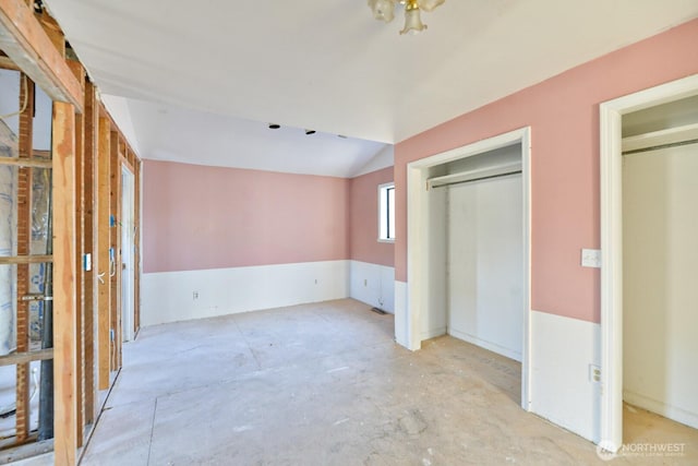 unfurnished bedroom with vaulted ceiling and a closet