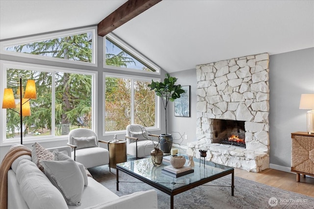 living room featuring a fireplace, lofted ceiling with beams, baseboards, and wood finished floors