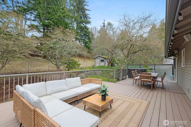 deck featuring outdoor dining space, an outdoor hangout area, a storage shed, and an outdoor structure