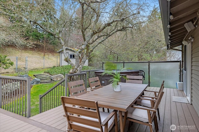 wooden terrace featuring outdoor dining space, fence, a shed, a yard, and an outdoor structure