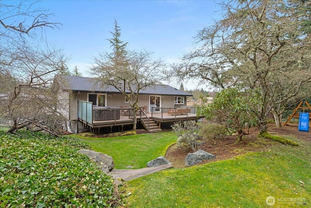 rear view of property featuring a wooden deck and a yard