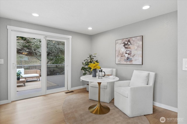 sitting room with recessed lighting, baseboards, visible vents, and light wood finished floors