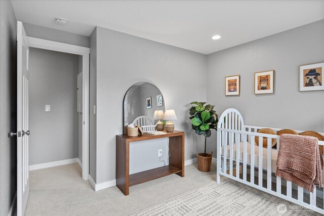 bedroom with carpet flooring, a nursery area, and baseboards