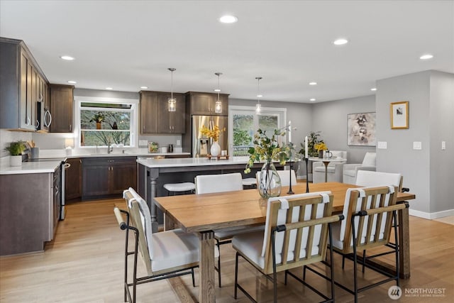 dining room with recessed lighting, baseboards, and light wood-style floors