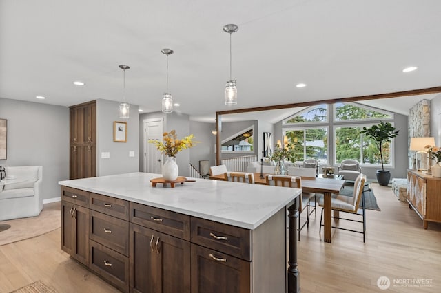 kitchen featuring lofted ceiling with beams, light wood-type flooring, recessed lighting, and hanging light fixtures