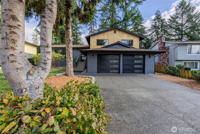 view of front facade with driveway and fence