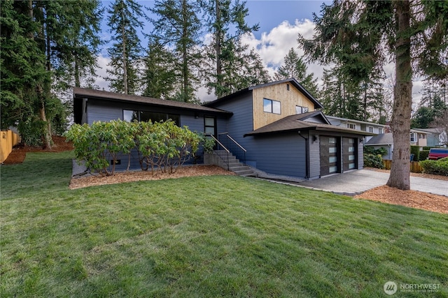 view of front of home with driveway, an attached garage, a front yard, and fence