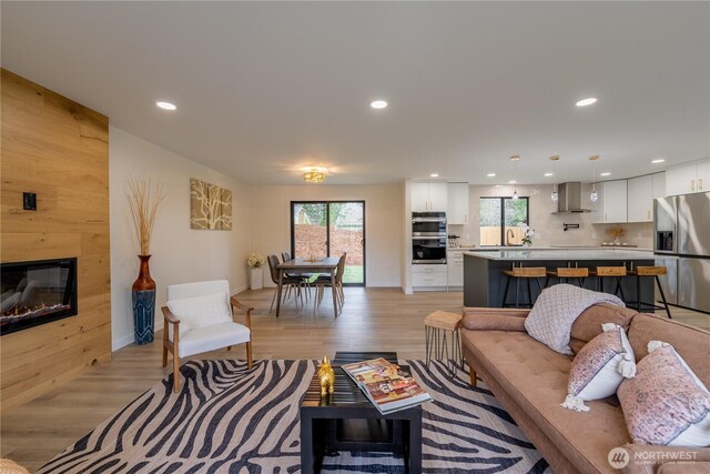 living room with a wealth of natural light, light wood-style flooring, and a fireplace