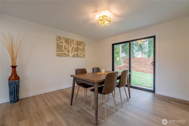 dining room featuring baseboards and light wood-type flooring