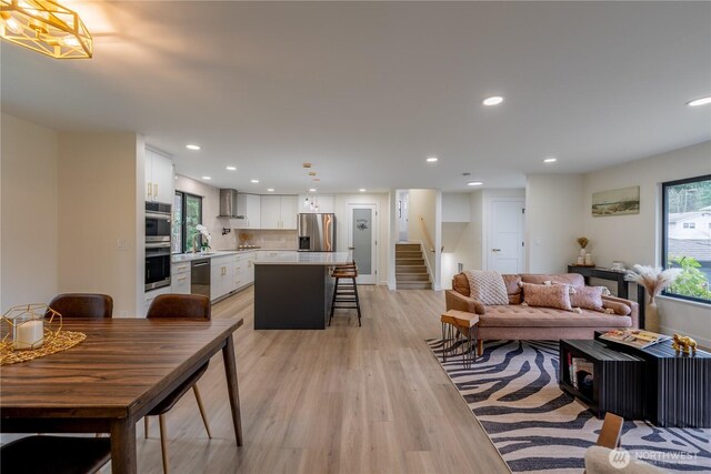 living area featuring stairway, recessed lighting, and light wood-type flooring