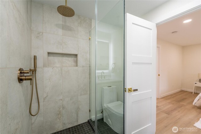 full bath with recessed lighting, wood finished floors, a stall shower, and baseboards