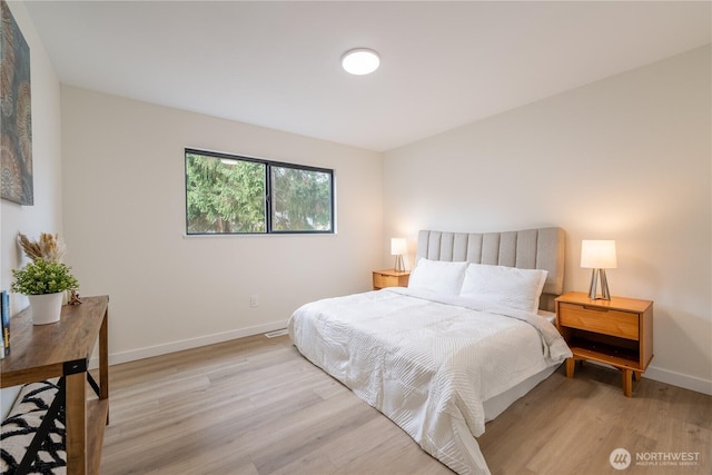 bedroom featuring baseboards and light wood finished floors