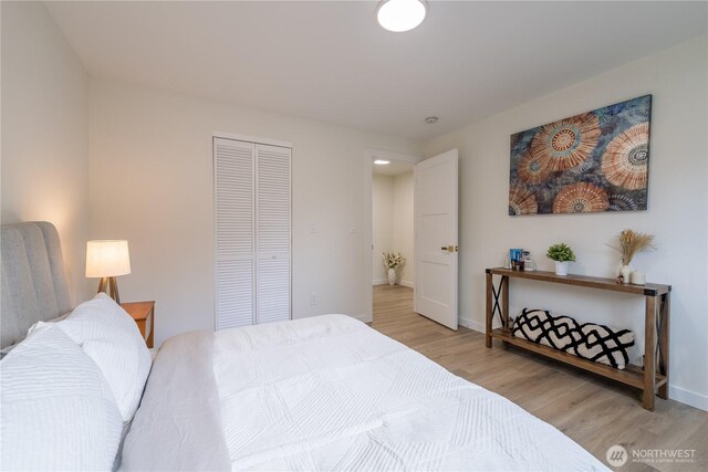 bedroom featuring a closet, baseboards, and light wood-style floors