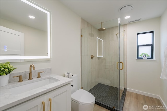 full bath featuring visible vents, toilet, wood finished floors, a shower stall, and vanity