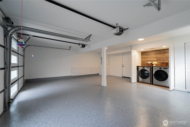 garage with a garage door opener and separate washer and dryer